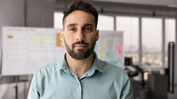 Man in an office with Kanban Board