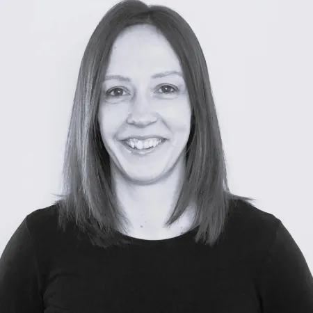 Portrait of a smiling woman with straight hair wearing a black top.