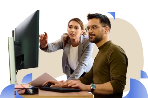 A man and a lady looking at a computer monitor during a discussion or presentation
