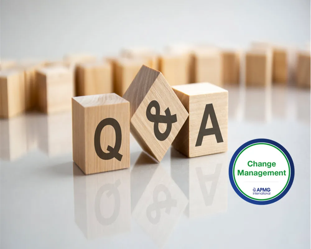 Wooden blocks spelling Q&A with small Change Management logo, arranged with wooden blocks in background