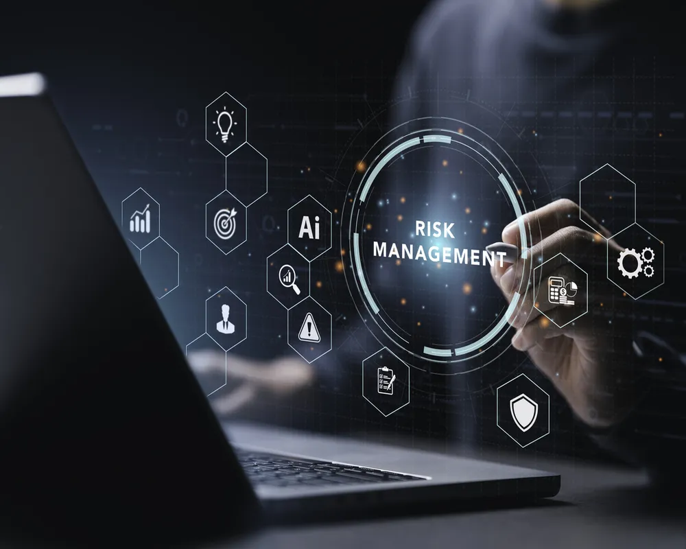 Person interacting with transparent digital risk management interface above laptop