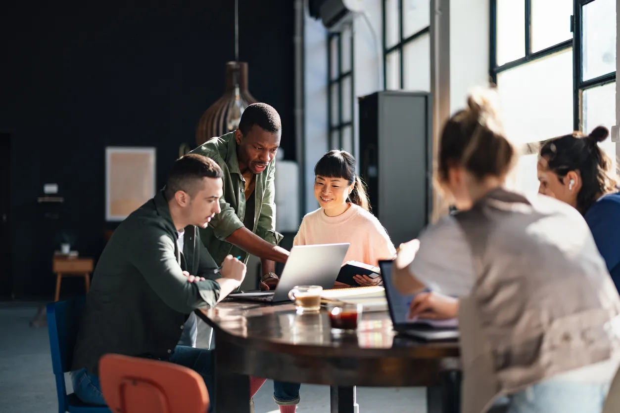 Groupe de personnes travaillant ensemble autour d'une table dans un bureau lumineux