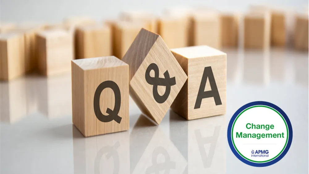 Wooden blocks spelling Q&A with small Change Management logo, arranged with wooden blocks in background