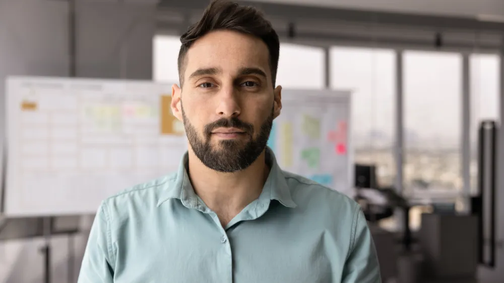 Man in an office with Kanban Board
