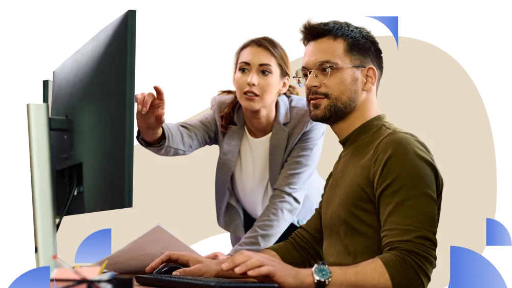 A man and a lady looking at a computer monitor during a discussion or presentation