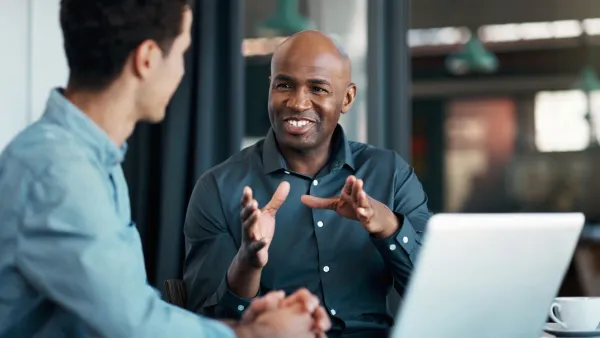 Two male office workers having a conversation in the office