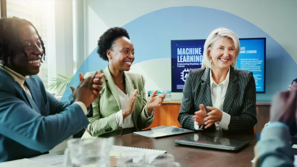 Three business professionals collaborating at a table, reviewing documents and discussing strategy.